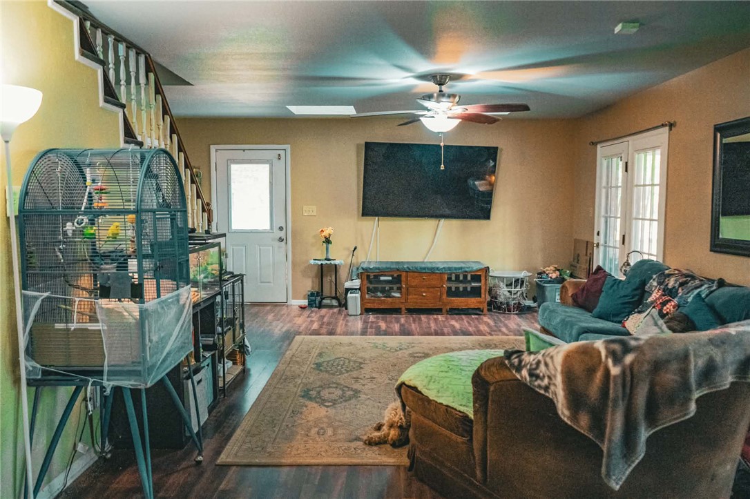 1014 Excelsior Road Greenwood, AR 72936 - Photo 23 of 37 Living area with dark wood-finish flooring, a contemporary ceiling fan with integrated lighting, and a skylight