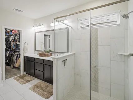 a bathroom with a double vanity sink mirror and shower