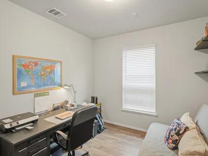a view of a workspace with furniture and a window