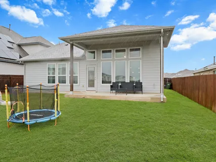 a backyard of a house with table and chairs