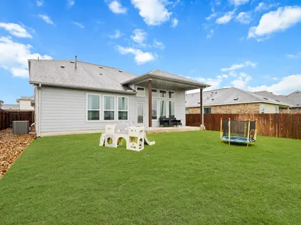 a backyard of a house with table and chairs