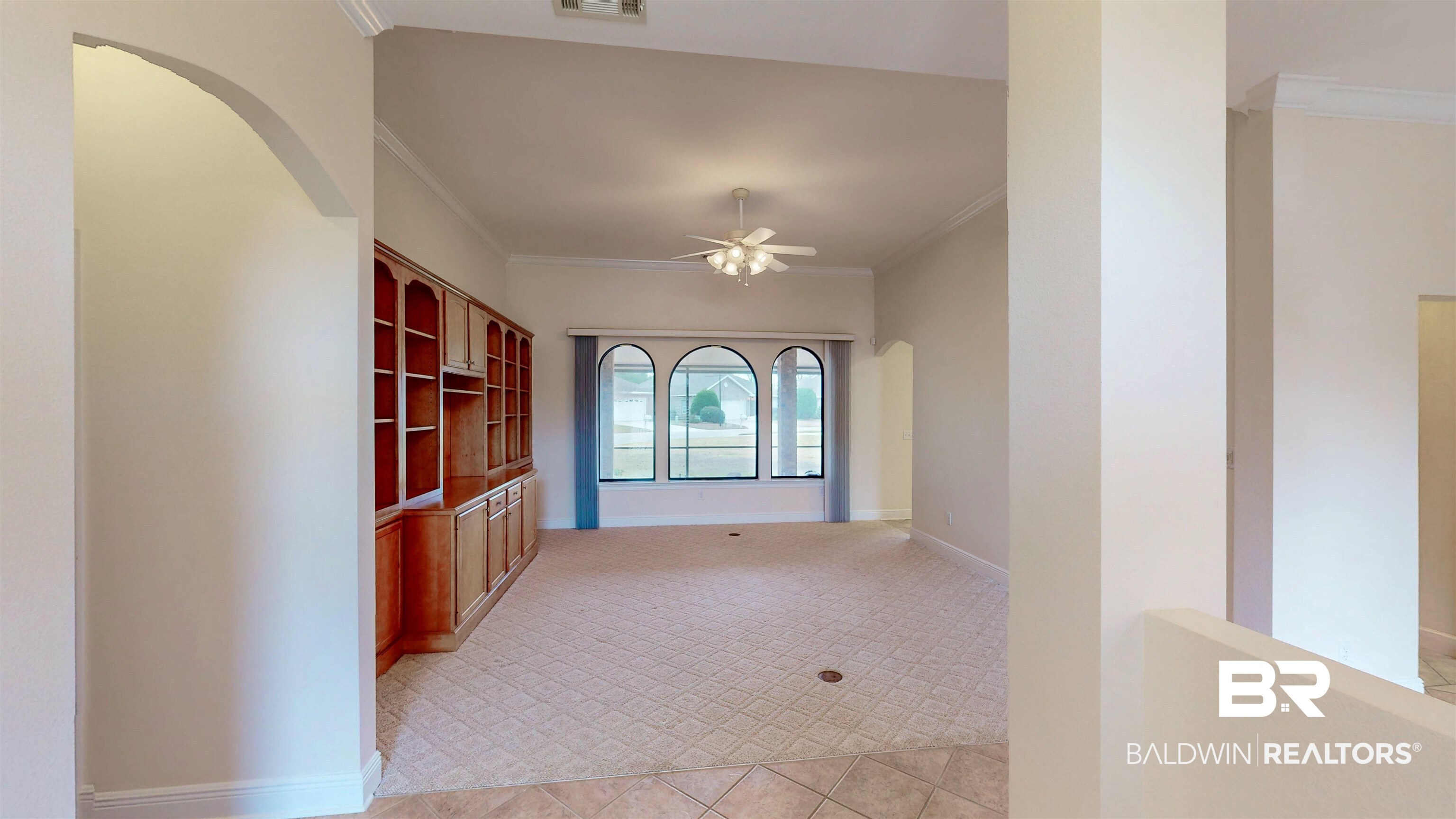 214 Hemingway Loop Foley, AL 36535 - Photo 7 of 67 Hallway with arched walkways, ornamental molding, and light tile patterned floors