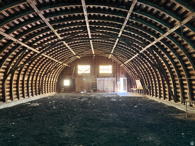 2002 Lund Road Bancroft, ID 83217 - Photo 23 of 28 Spacious arched structure featuring exposed wood beam framing, multiple window openings providing ambient light, and a large open floor area