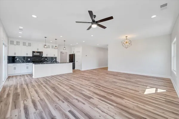 a view of a kitchen with wooden floor and a window