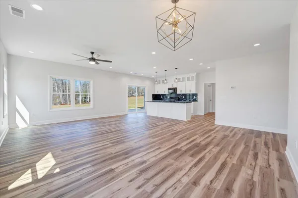 a large kitchen with stainless steel appliances a large counter top a sink and a window