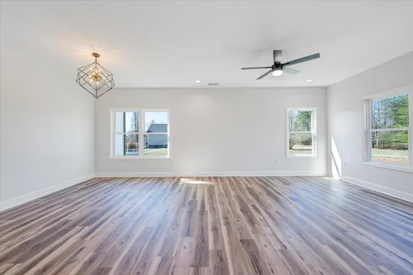 a kitchen with stainless steel appliances granite countertop a sink stove and white cabinets with wooden floor