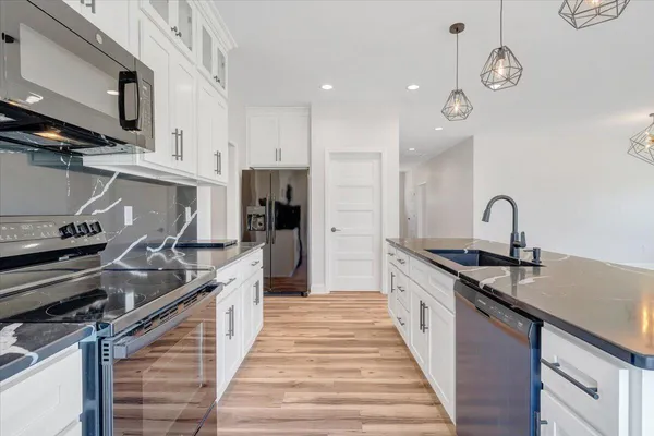 a bathroom with a granite countertop sink a toilet and a mirror