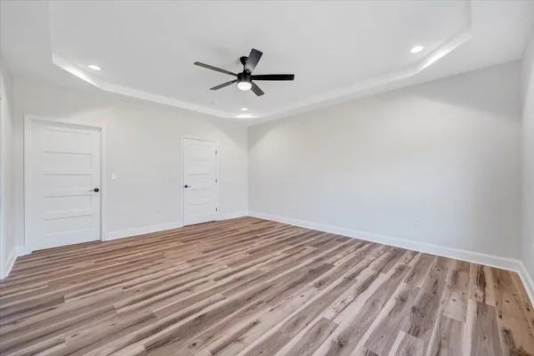 a view of an empty room with window and wooden floor
