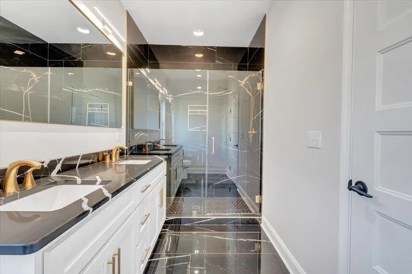 a bathroom with a granite countertop sink a toilet a mirror and bathtub