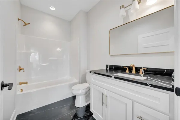 a front view of house with yard and trees in the background