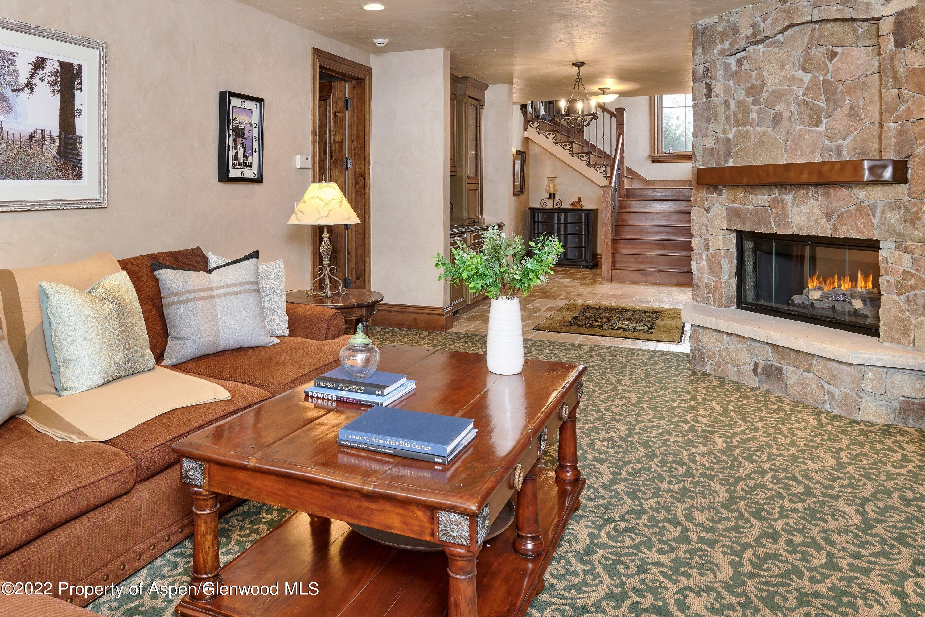 64 Spruce Ridge Lane Snowmass Village, CO 81615 - Photo 22 of 37 a living room with furniture a table and a fireplace