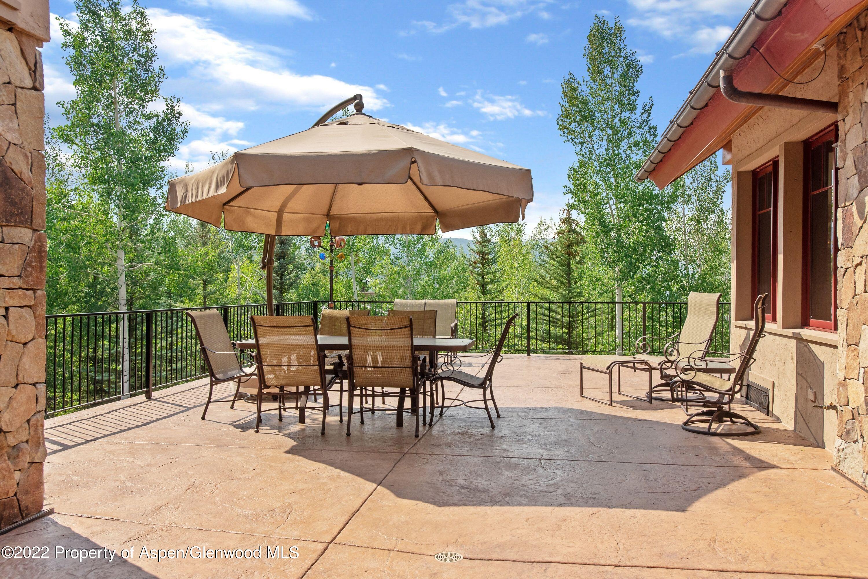 64 Spruce Ridge Lane Snowmass Village, CO 81615 - Photo 29 of 37 a view of a patio with a table and chairs under an umbrella
