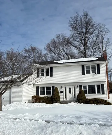 a front view of a house with a yard covered in snow