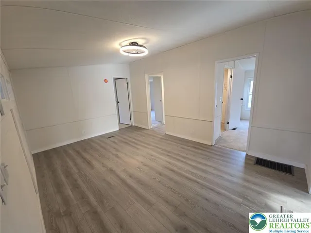 a view of empty room with wooden floor