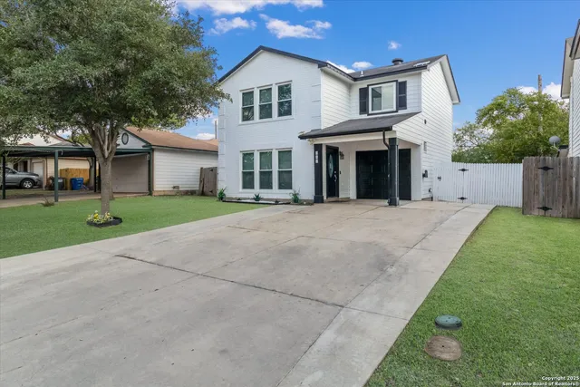 a front view of a house with a yard and trees