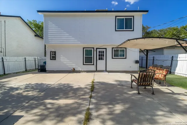 a backyard of a house with table and chairs