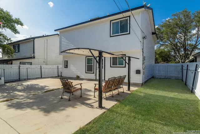 a backyard of a house with table and chairs