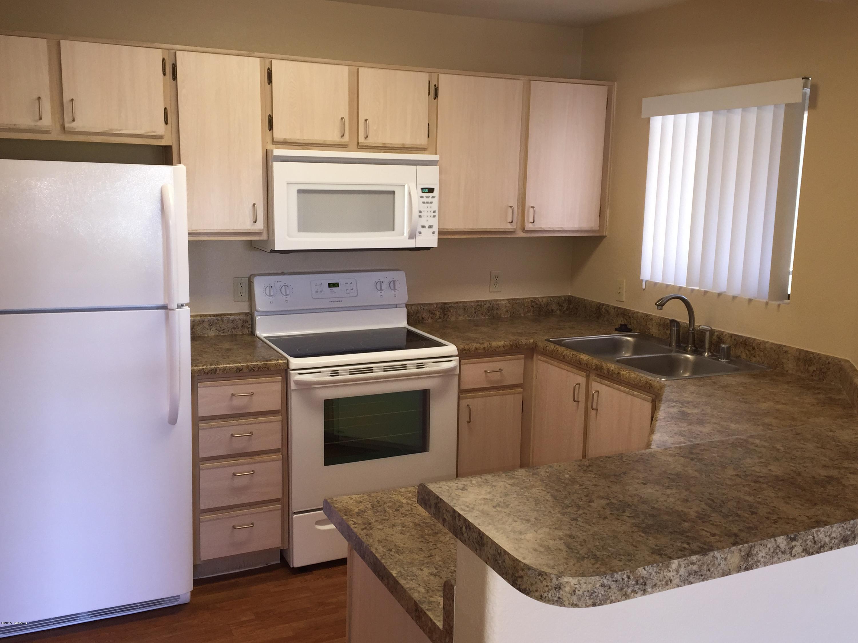 5751 North Kolb Road, Unit 28201 Tucson, AZ 85750 - Photo 1 of 14 a kitchen with granite countertop a sink cabinets and stainless steel appliances