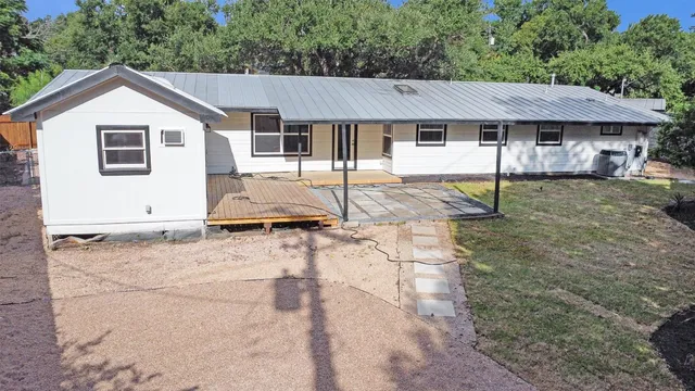 a view of a house with a yard tree and a fence
