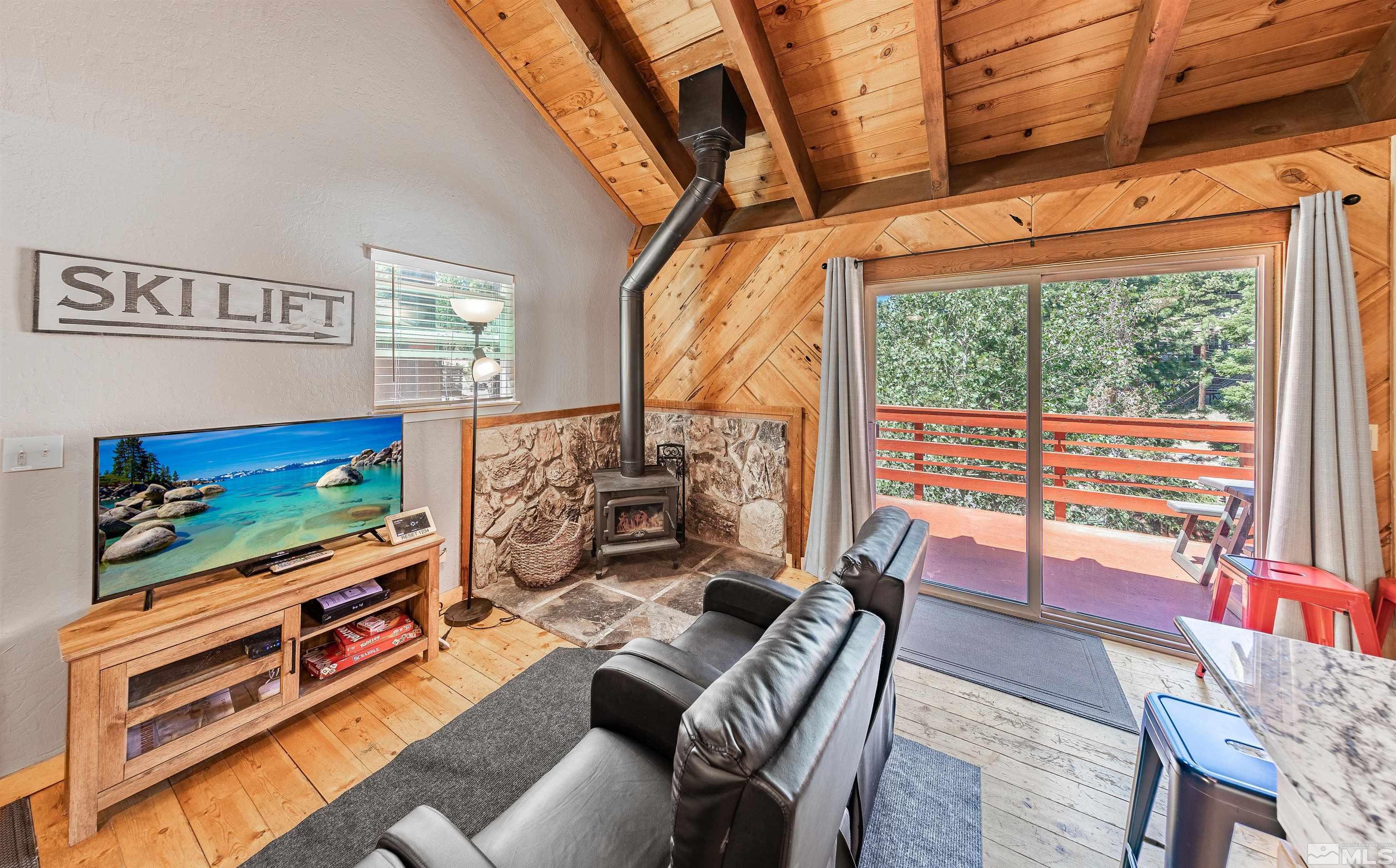 181 Tramway Drive, Unit B Stateline, NV 89449 - Photo 2 of 27 a living room with furniture a flat screen tv and a floor to ceiling window