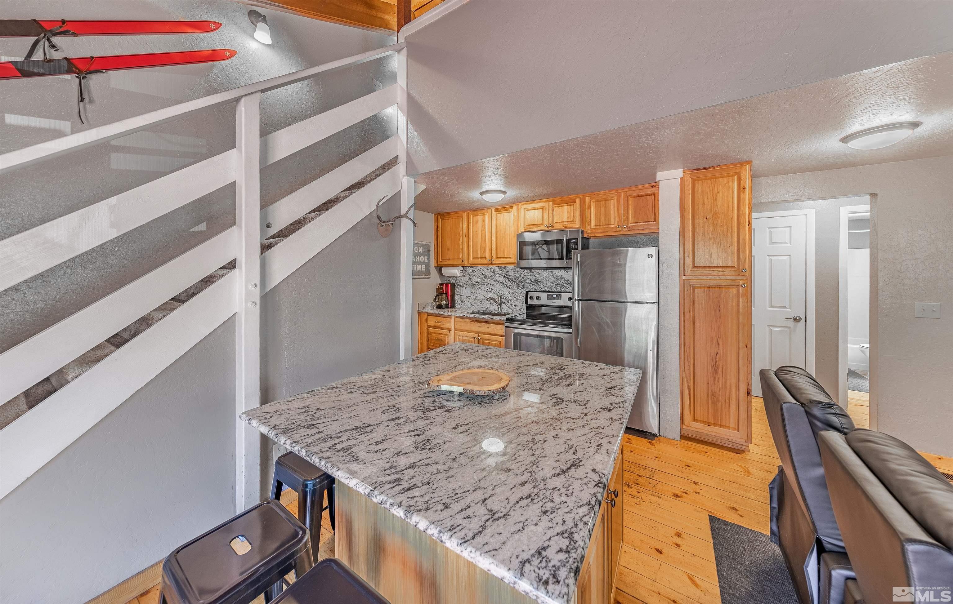 181 Tramway Drive, Unit B Stateline, NV 89449 - Photo 6 of 27 a kitchen with stainless steel appliances granite countertop a sink and refrigerator