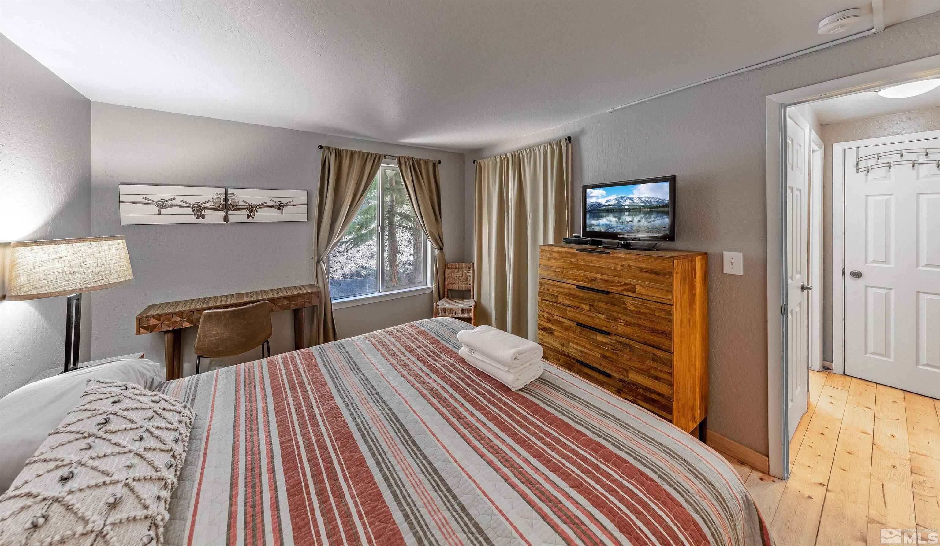 181 Tramway Drive, Unit B Stateline, NV 89449 - Photo 9 of 27 a bedroom with a bed and wooden floor