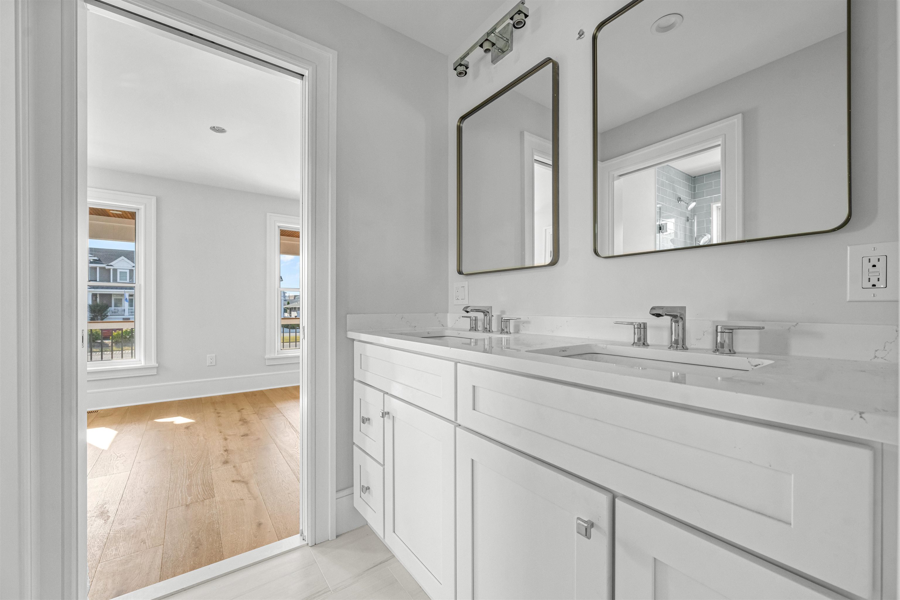 1819 Dune Drive Avalon, NJ 08202 - Photo 12 of 49 a bathroom with double vanity sink two mirror and a window