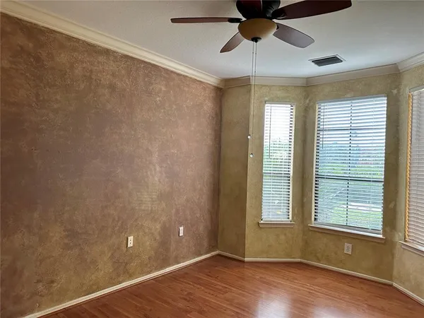 a view of an empty room with a window and wooden floor