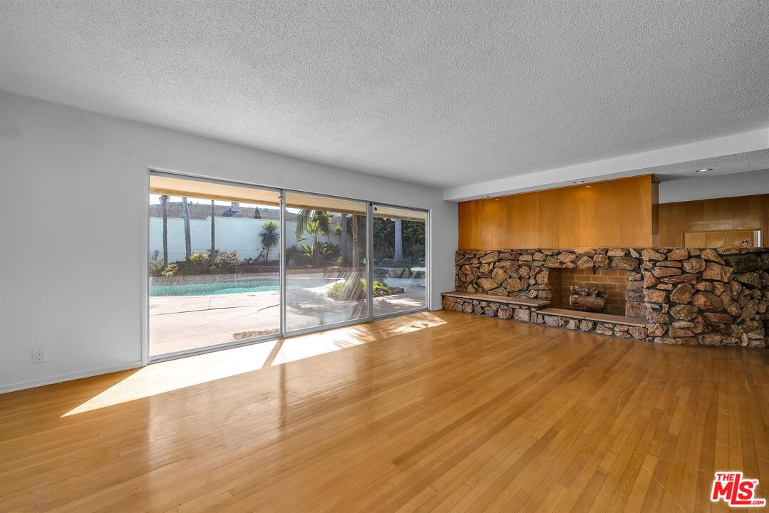 4320 Monteith Drive View Park, CA 90043 - Photo 3 of 17 an empty room with floor to ceiling window and wooden floor