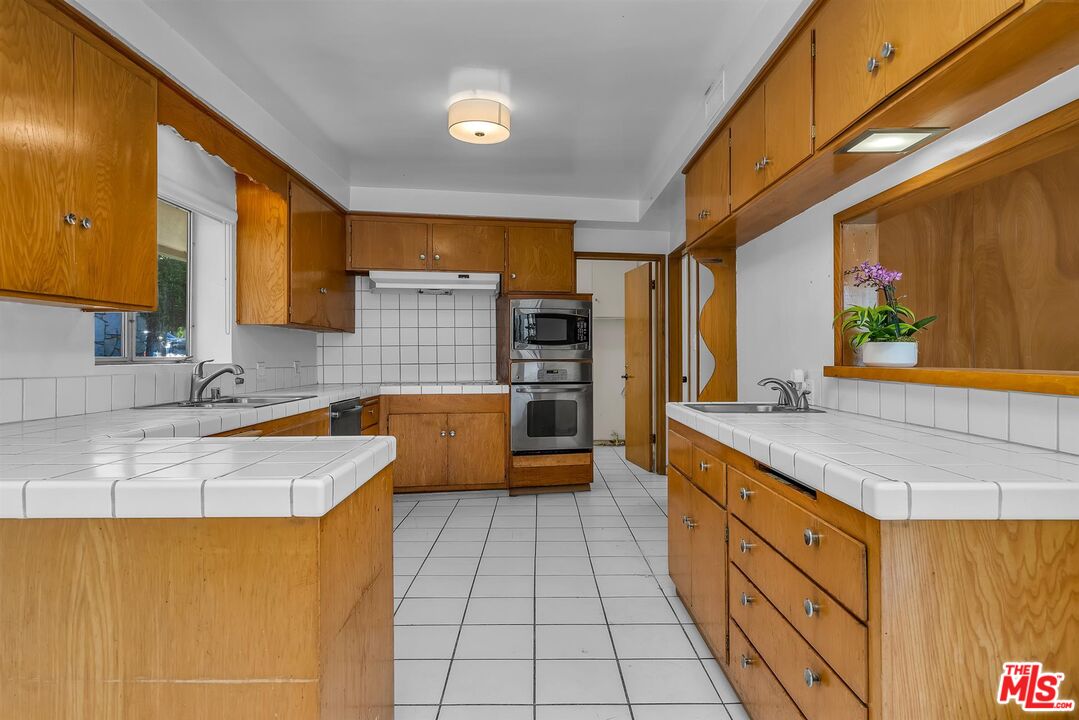 4320 Monteith Drive View Park, CA 90043 - Photo 5 of 17 a kitchen with stainless steel appliances granite countertop a sink and a stove