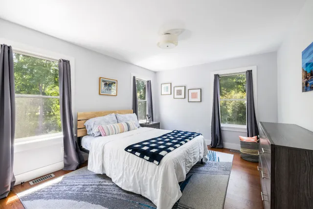 a bedroom with a bed lamp and a window