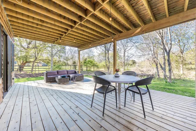 a view of a patio with table and chairs and wooden floor