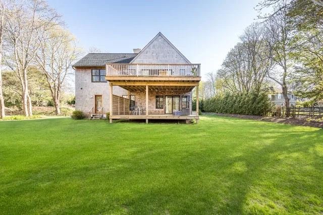 a view of a house with a big yard and large trees