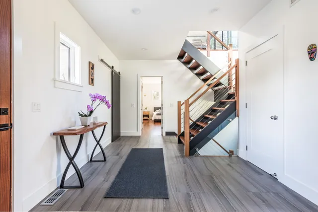 a view of entryway and hall with wooden floor