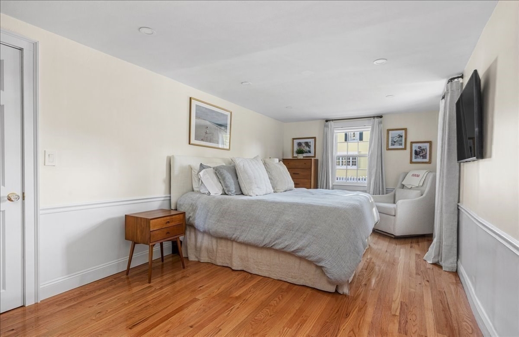 12 Merrymount Road Hingham, MA 02043 - Photo 13 of 18 a spacious bedroom with a bed and a table in it