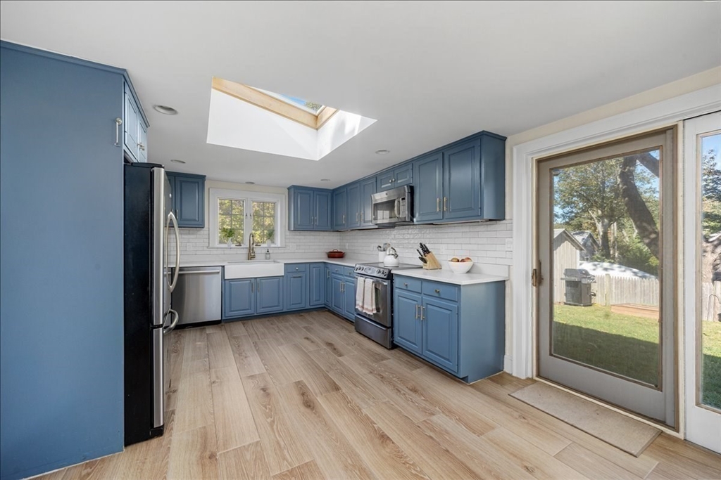 12 Merrymount Road Hingham, MA 02043 - Photo 10 of 18 a kitchen with stainless steel appliances kitchen island wooden cabinets a stove a sink and a large window