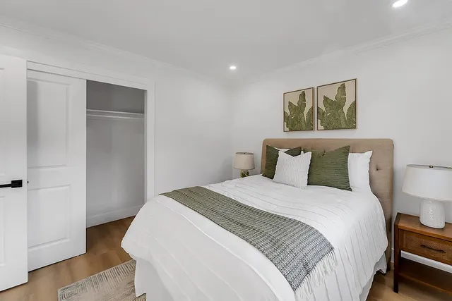 a bedroom with bed and wooden floor