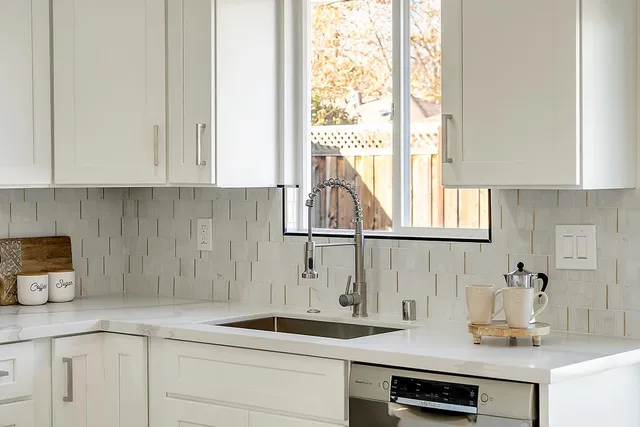 a kitchen with sink a window and cabinets
