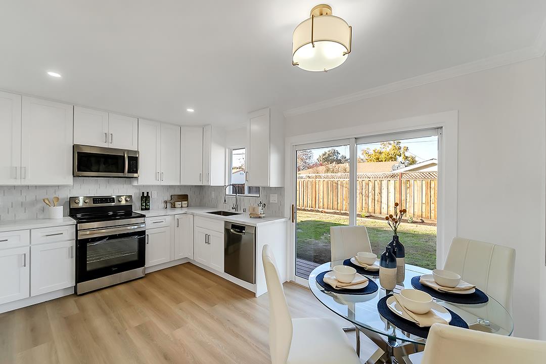 527 Maple Avenue Milpitas, CA 95035 - Photo 10 of 30 a kitchen with stainless steel appliances granite countertop a stove top oven a sink dishwasher a dining table and chairs with wooden floor