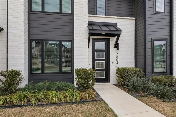 a view of a brick house with potted plants