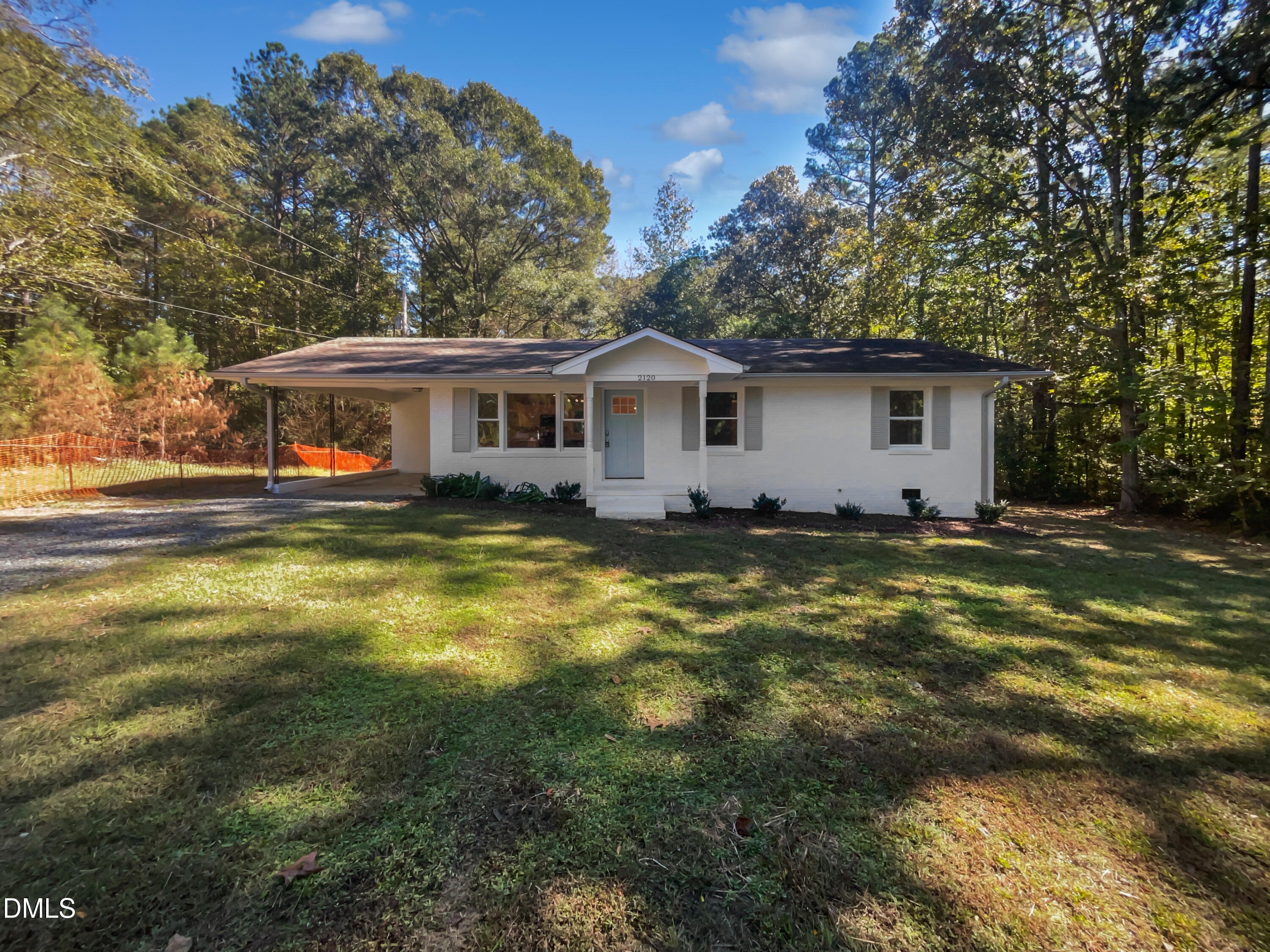 a view of a house with a big yard and large trees