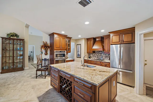 a kitchen with stainless steel appliances granite countertop a refrigerator and a stove top oven