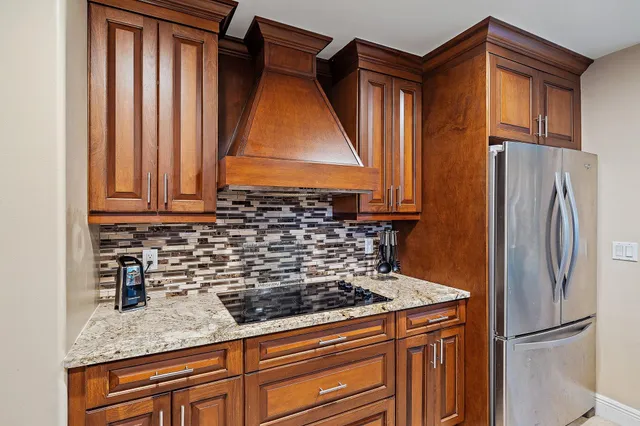 a kitchen with granite countertop a sink and a refrigerator