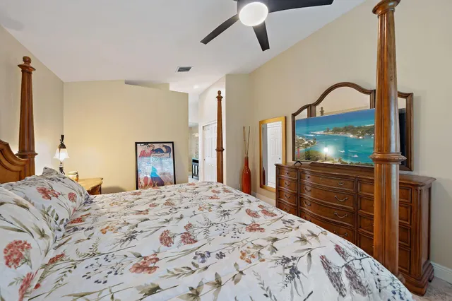 a bedroom with a bed and a dresser with mirror