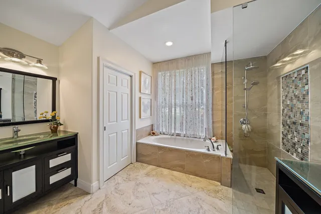 a bathroom with a tub shower and sink