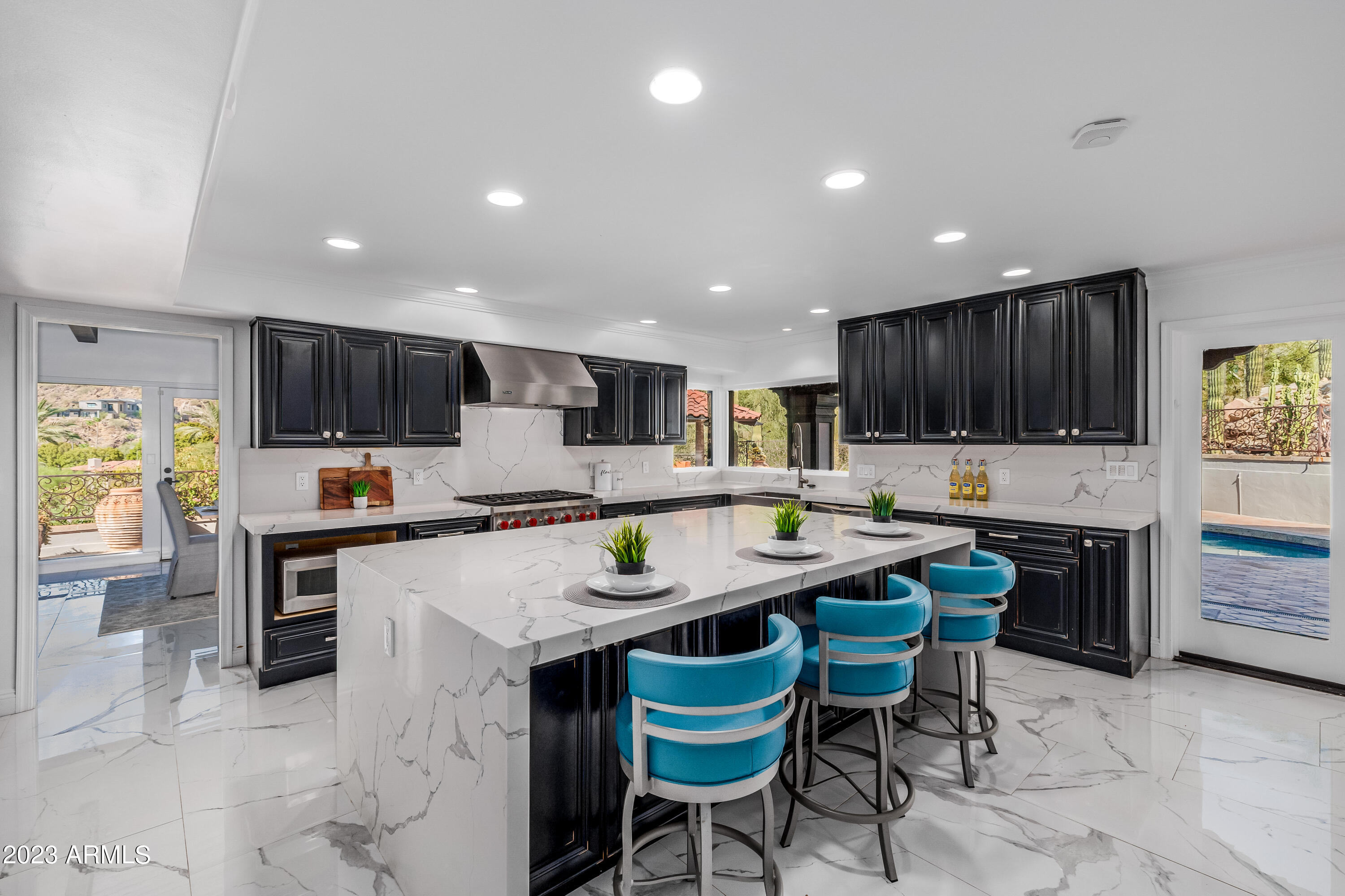 5339 East Desert Vista Road Paradise Valley, AZ 85253 - Photo 20 of 93 a kitchen with stainless steel appliances granite countertop a table chairs sink refrigerator and cabinets