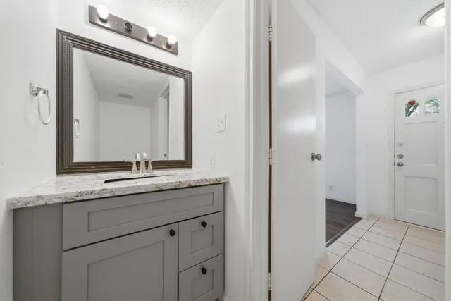 a bathroom with a granite countertop sink a mirror and a shower