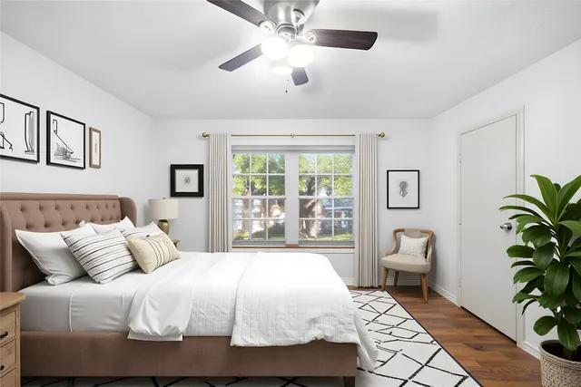 a bedroom with a large bed and a potted plant