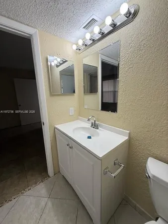 a bathroom with a sink a toilet and mirror