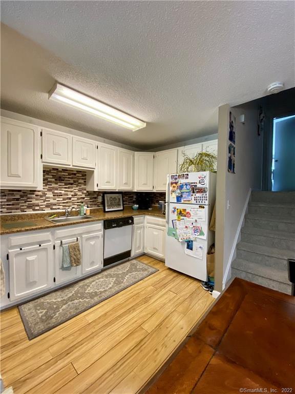 50 East Hill Road, Unit 2I Canton, CT 06019 - Photo 1 of 1 a kitchen with granite countertop white cabinets and white appliances